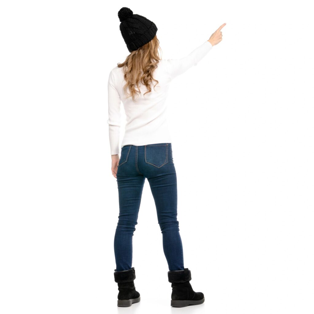Beautiful woman in sweater jeans hat cold showing