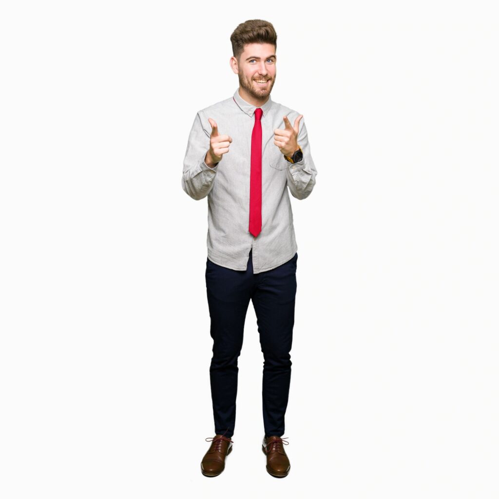 Young handsome business man pointing fingers to camera with happy and funny face. Good energy and vibes.