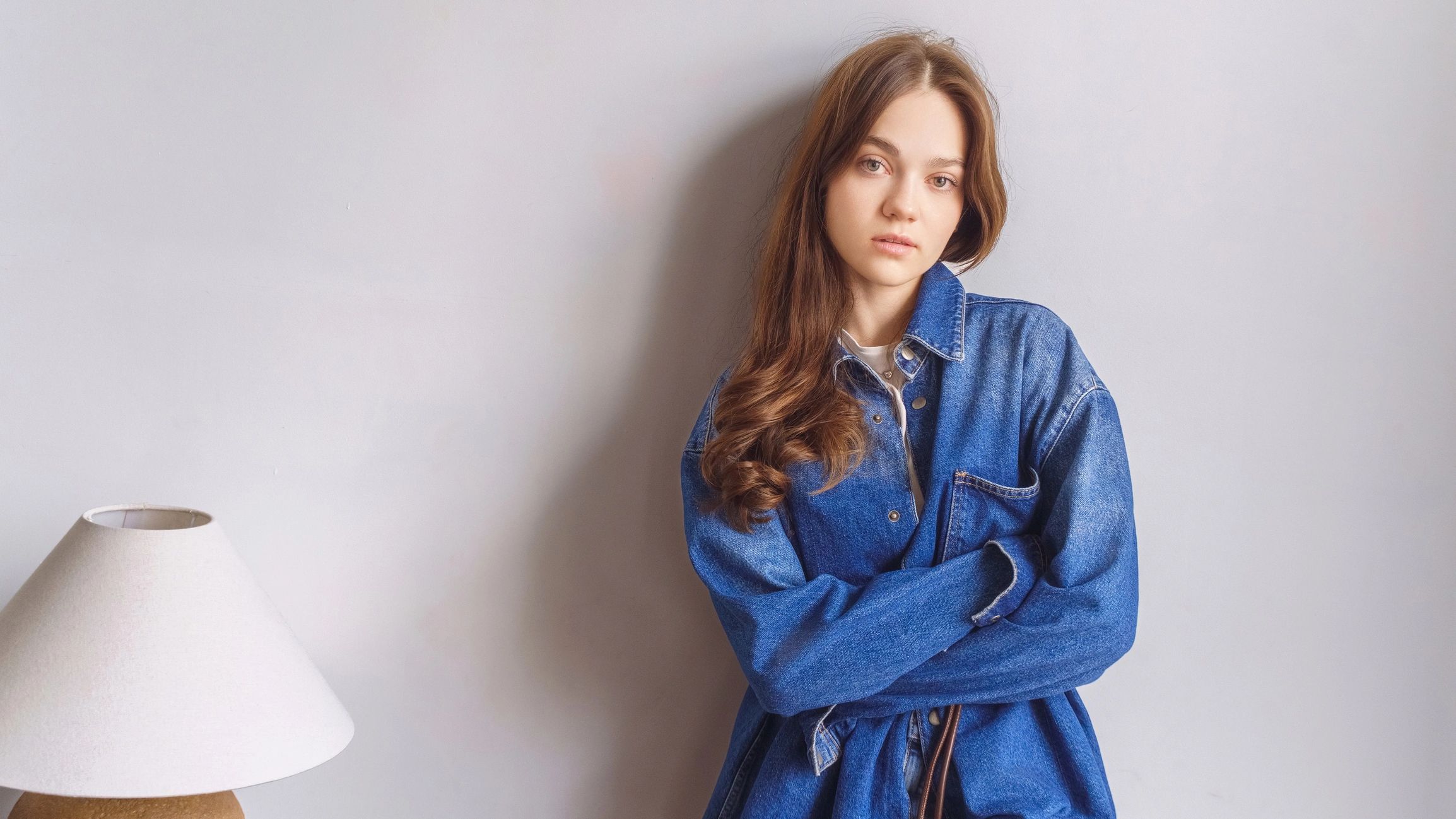 Model in denim clothing posed in a minimal studio